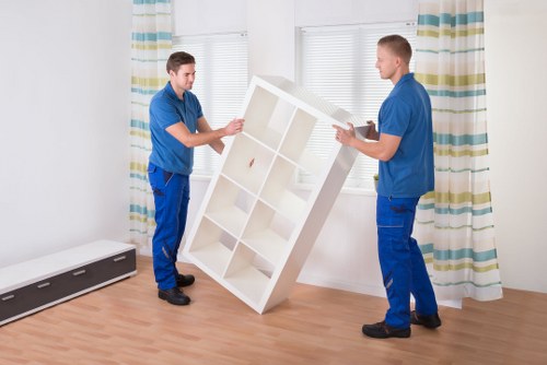 Professional movers carrying furniture through a Crystal Palace property