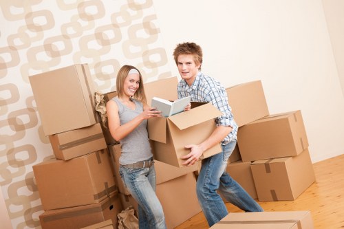 Trained removals staff carrying furniture carefully inside a property
